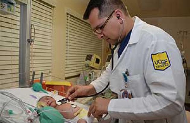 Medical resident measuring vital signs of infant