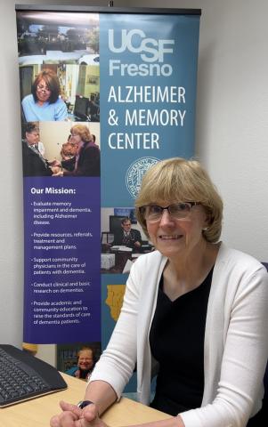 Loren Alving, MD, sits in front of a UCSF Fresno Alzheimer and Memory Center sign