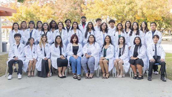 High school students in white coats seated