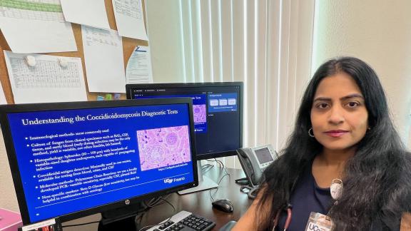 Geetha Sivasubramanian, MD, sitting next to computer screen