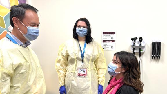 Doctor and medical resident talk to patient 