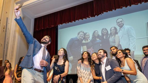 UCSF Fresno graduates take a selfie photo on stage 