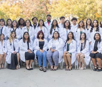 High school students in white coats seated