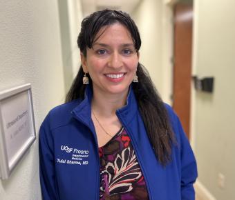 Dr. Tulsi Sharma, smiling, standing in hallway