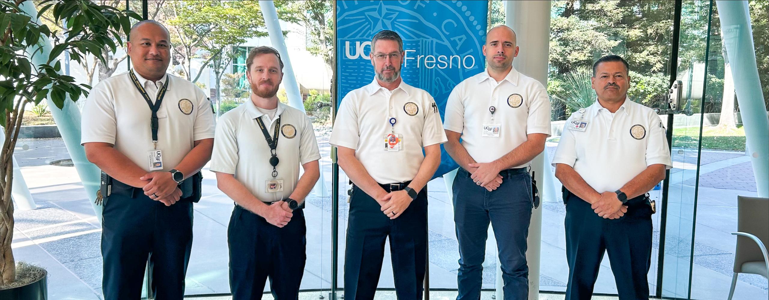 UCSF Fresno Public Safety Team posing in front of UCSF Fresno banner in the UCSF Fresno Lobby.