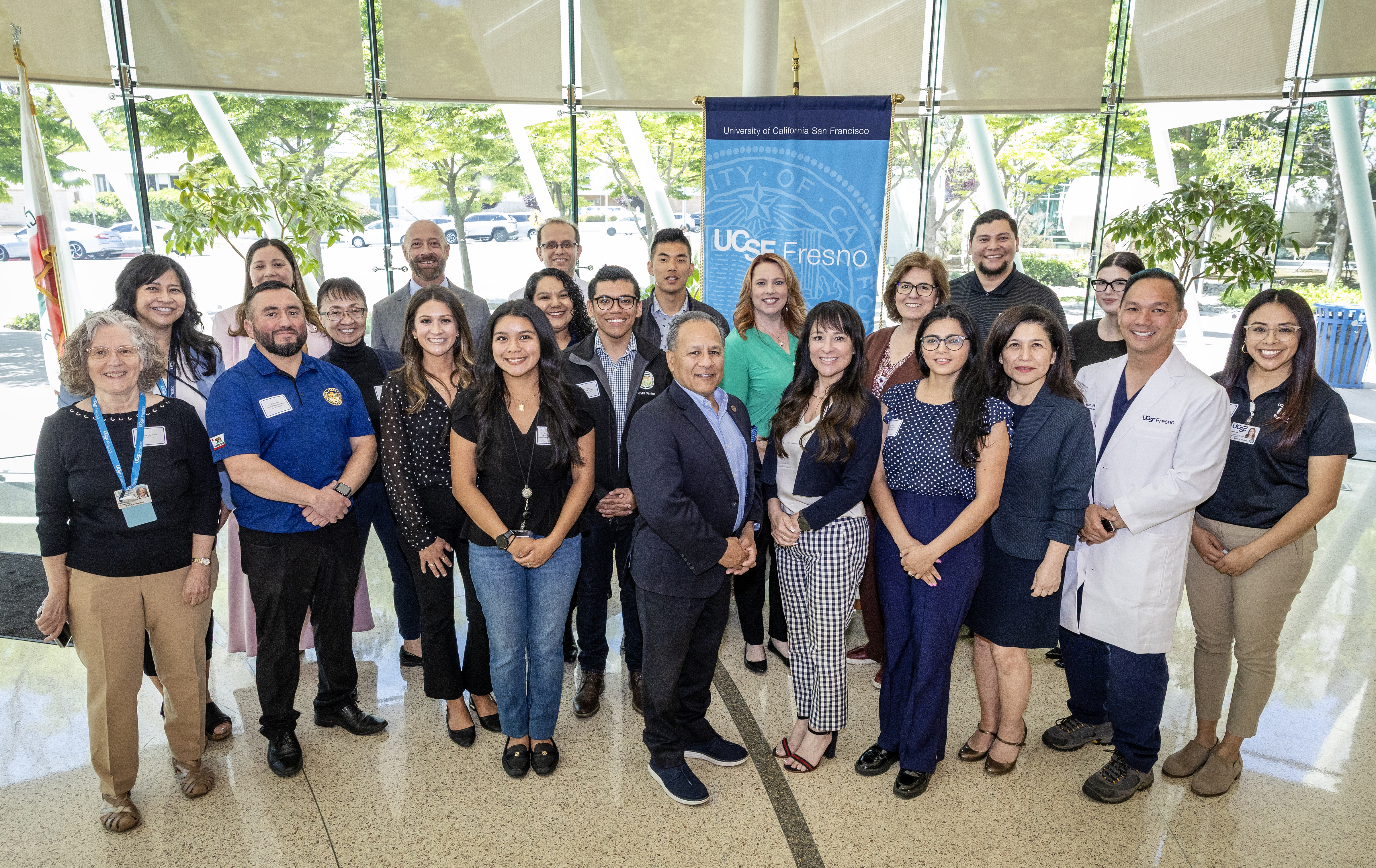 Group of people standing in front of UCSF Fresno banner