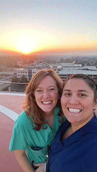 Two women taking a selfie at sunset on the rooftio CRMC helipad