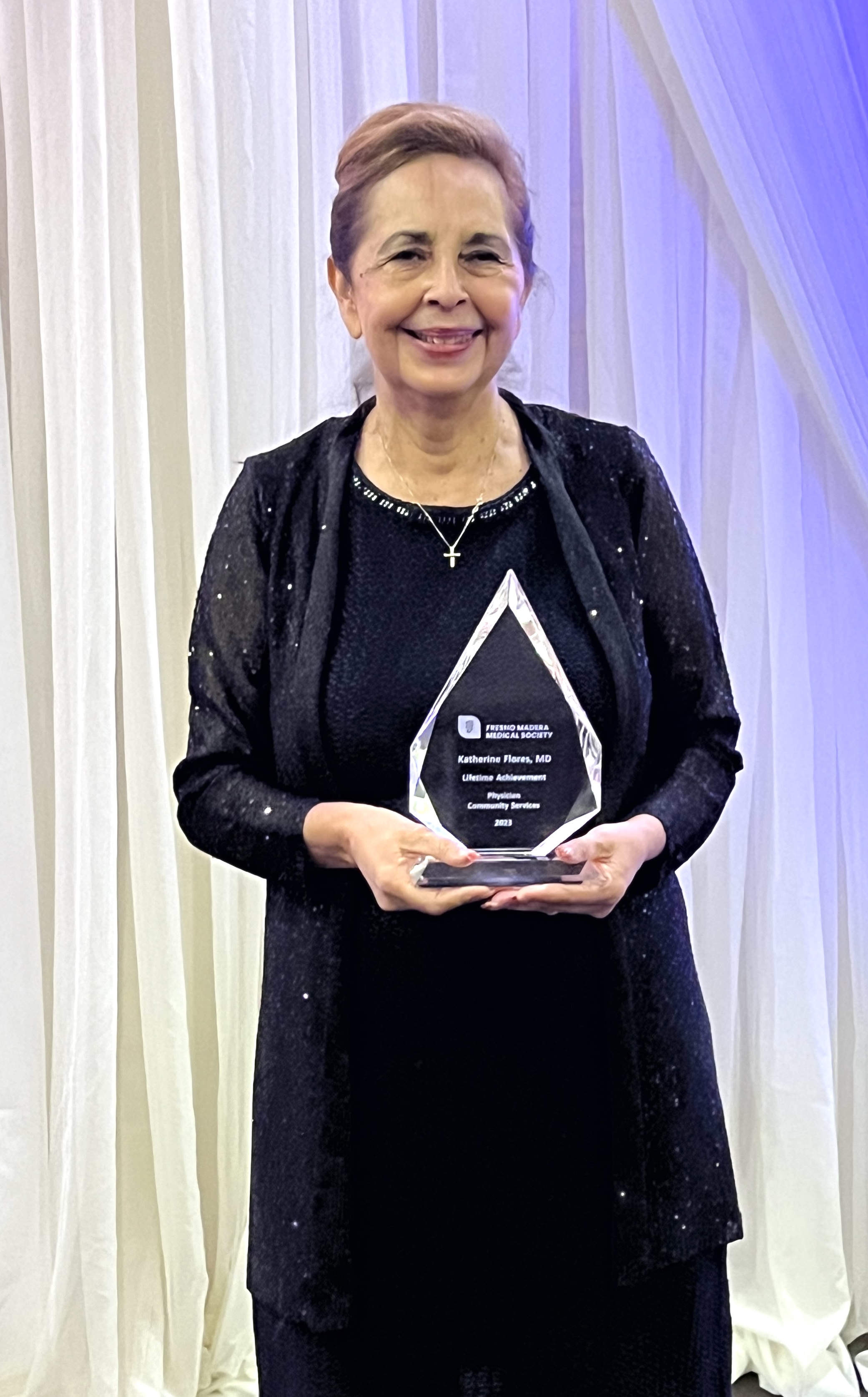 Dr. Katherine Flroes posing with an award