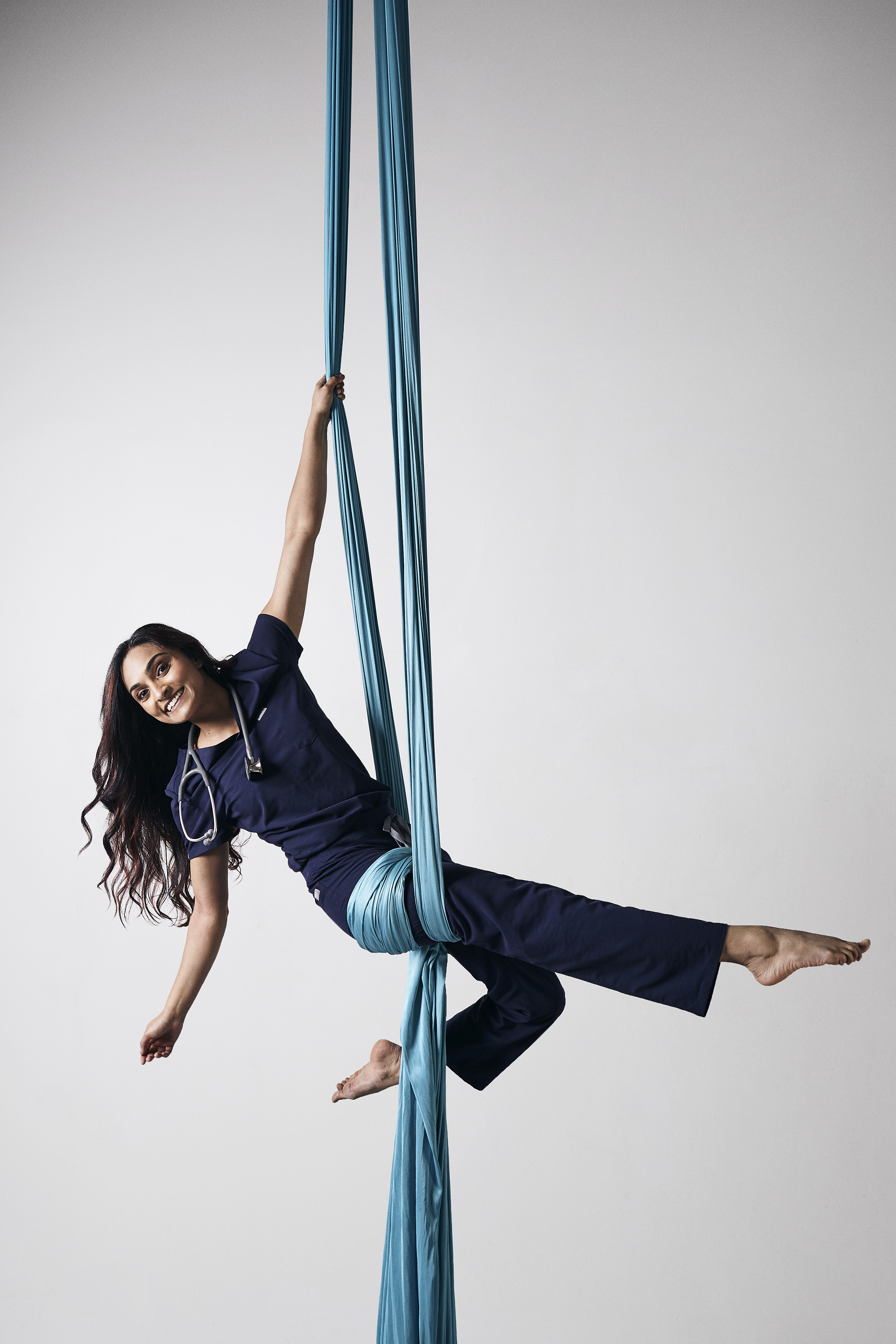 Ranjita Raghavan performing aerial acrobatics in scrubs.