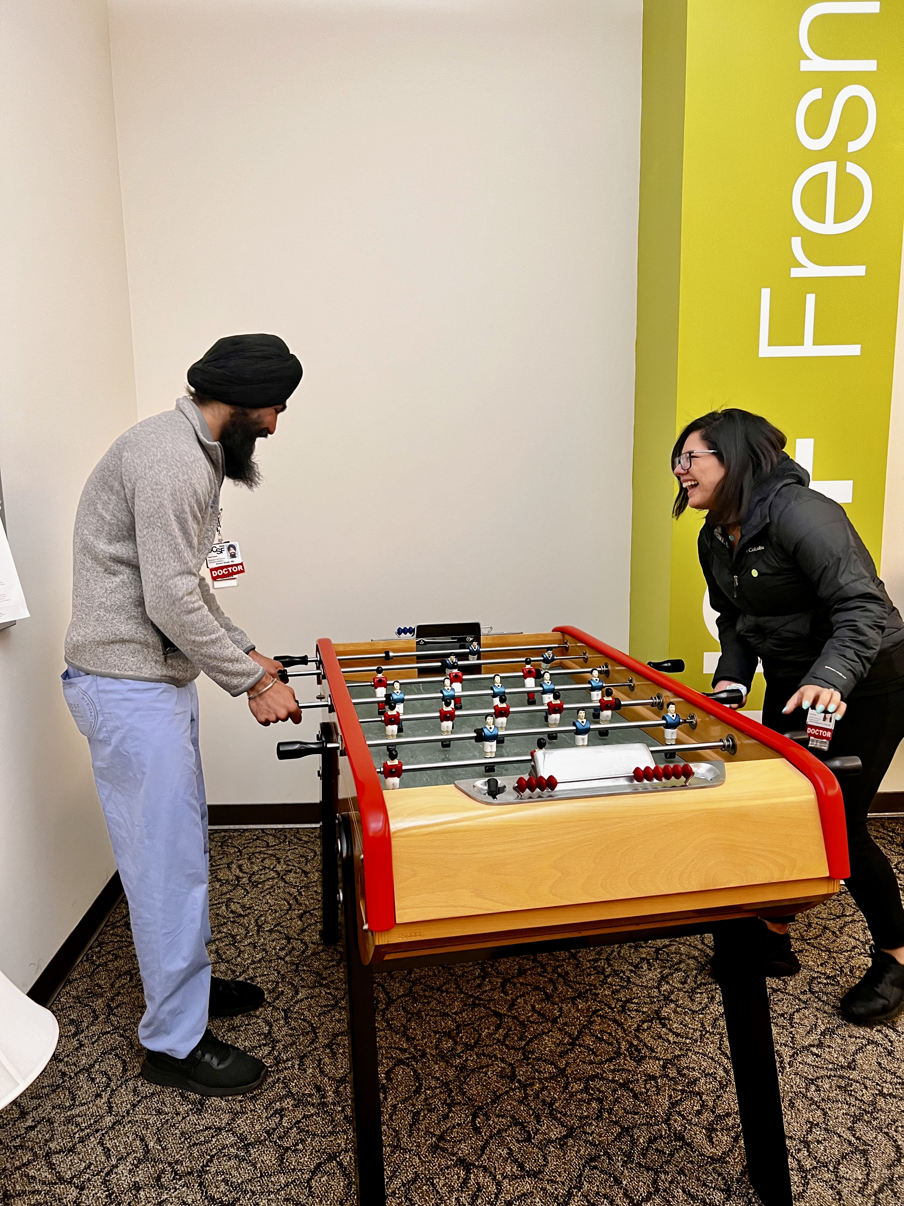 Students playing foosball in redesigned lounge room.